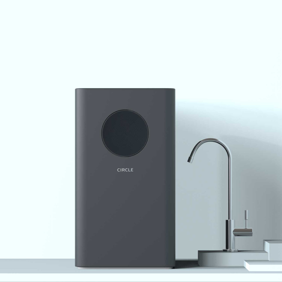 Brondell Circle countertop water filtration system beside a chrome dispenser tap on a white kitchen counter
