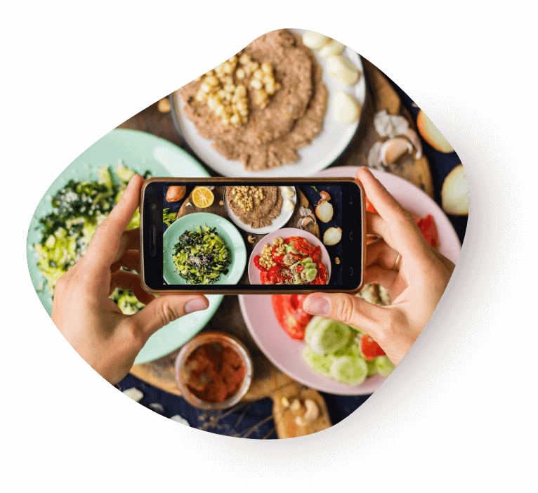 Creator photographing a spread of food with a phone